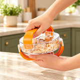 Hands holding the assembled clear chicken shredder with shredded chicken inside